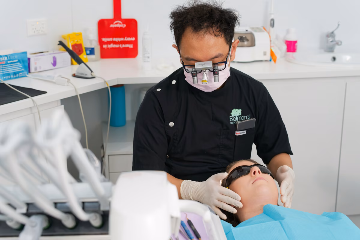 Balmoral Dental clinician assessing a patient's jaw and supporting muscles